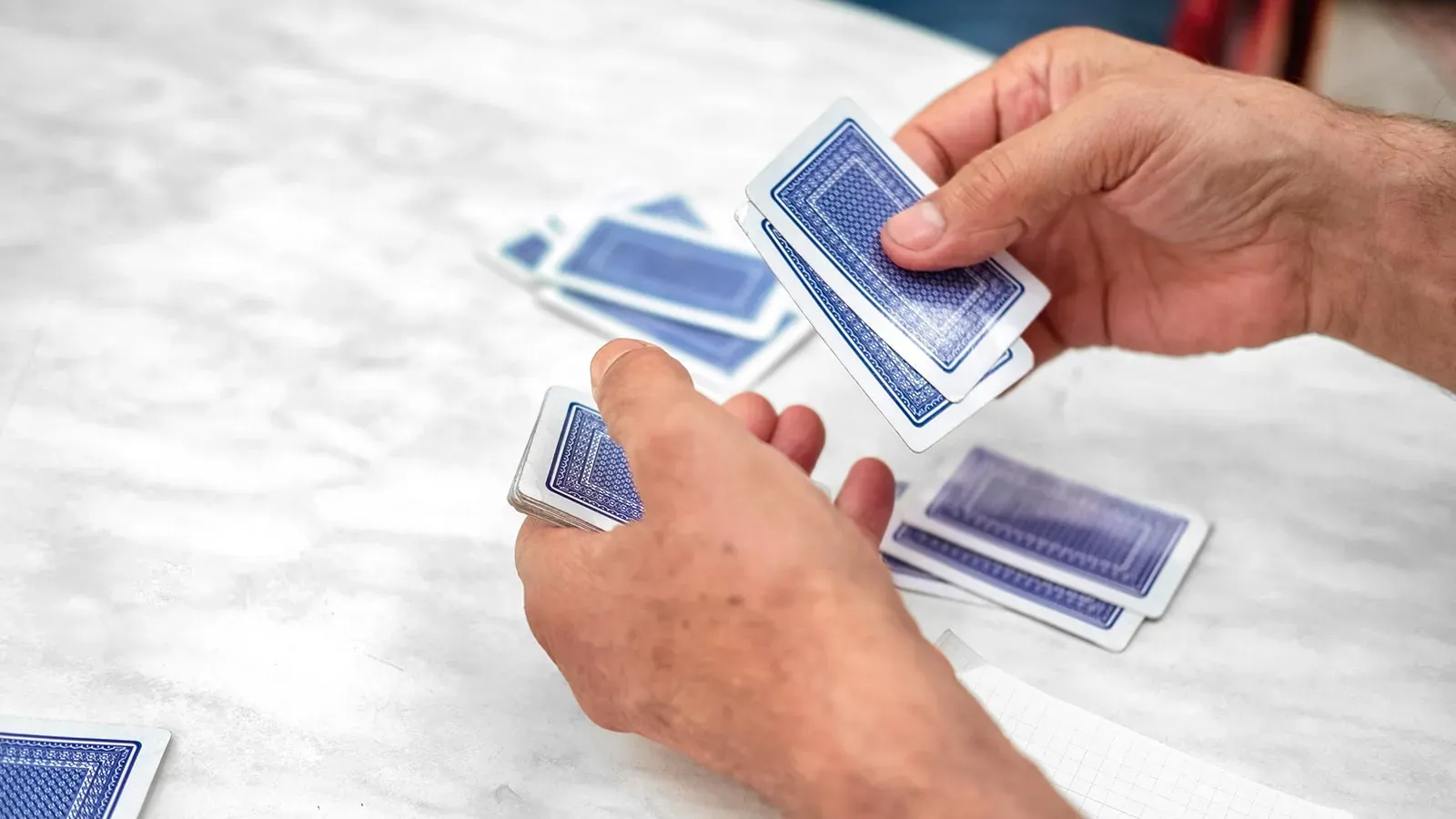 Mani di un giocatore che distribuisce le carte a burraco